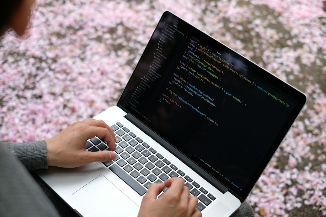 student coding on laptop