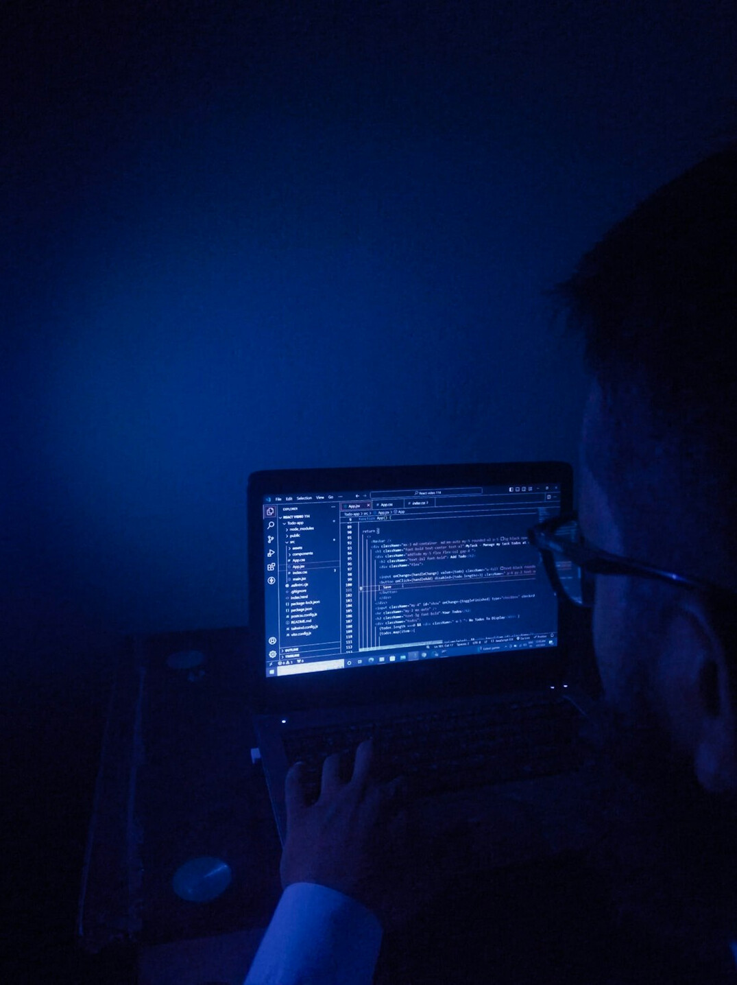 programmer typing code on laptop