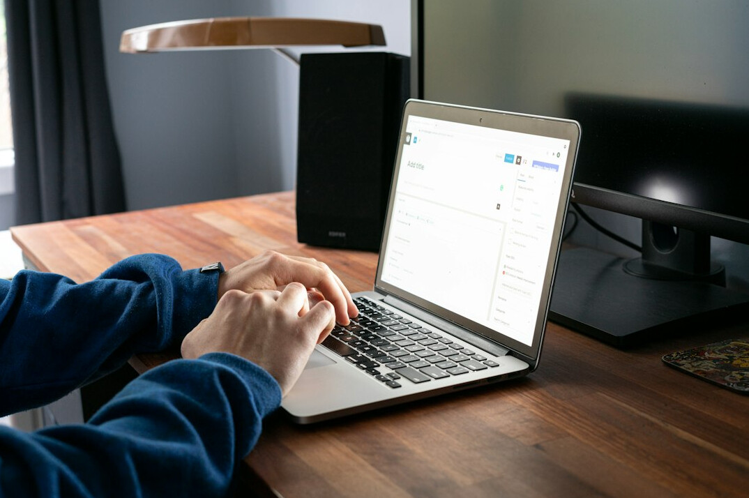 person coding on laptop
