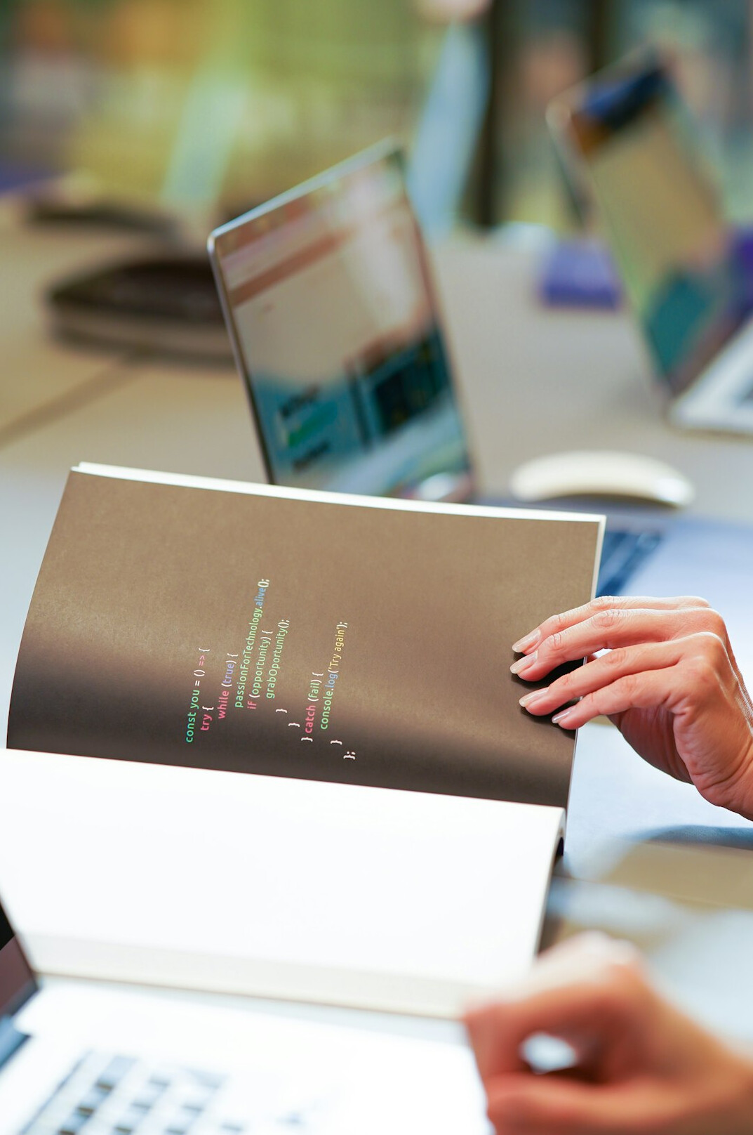 person coding on laptop with books